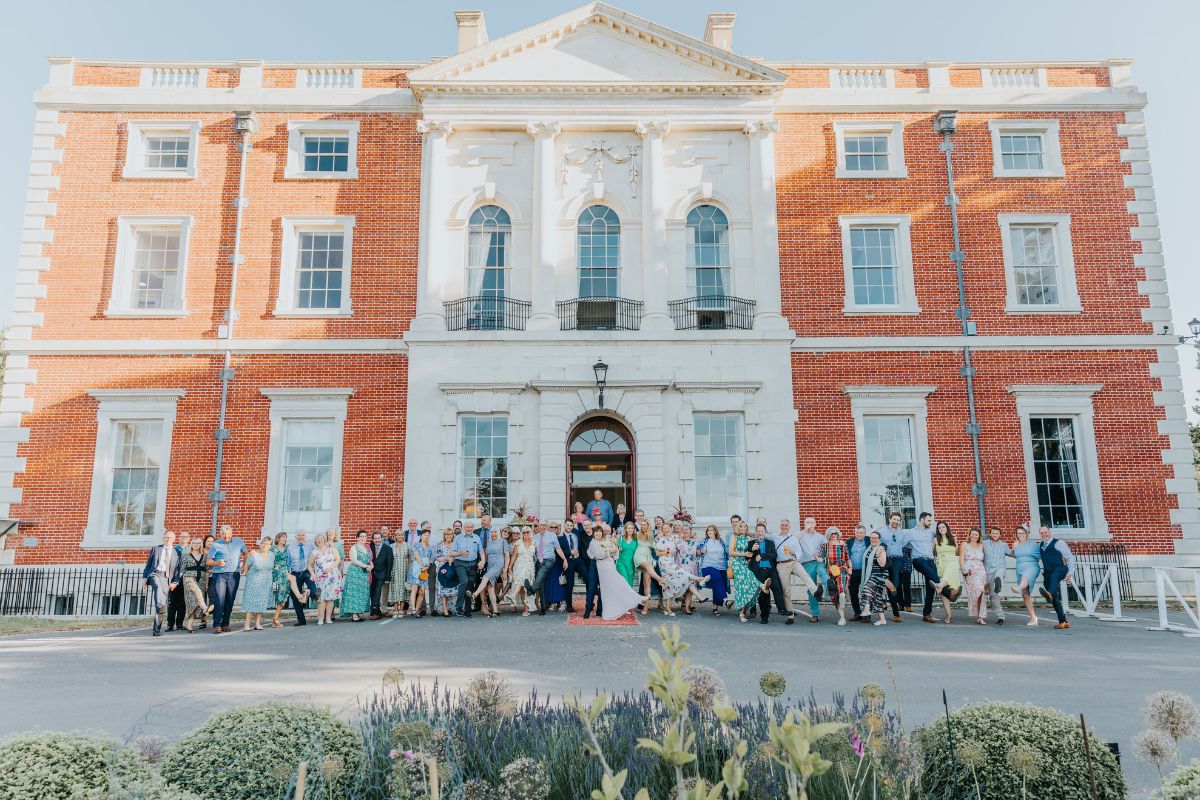 Wedding guests posing for a photo in front of Merley House