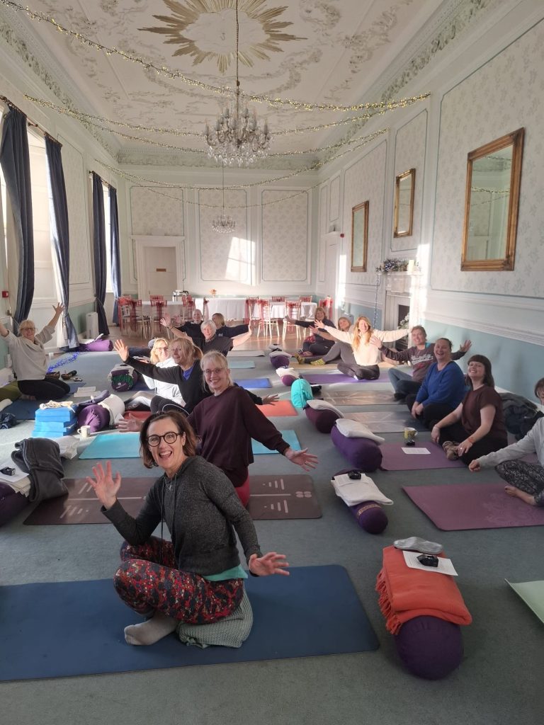 A photo of a group of people participating in a Hatha yoga class in the Old Library function room at Merley House.